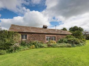 uma antiga casa de tijolos com um quintal verde em 2 Bed in Eden Valley SZ269 em Kirkoswald