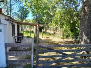 een houten hek voor een huis bij Los Aloes, Casa de campo in Las Toninas