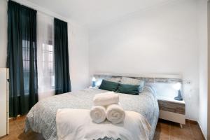 um quarto com uma cama com toalhas em La Torre de Cádiz em Cádiz