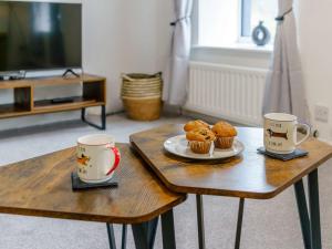 two coffee tables with two cups and muffins on them at 2 Bed in Cockermouth 85680 in Bridekirk