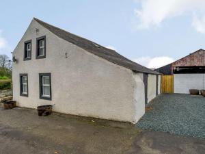 een wit gebouw met een garage en een schuur bij 2 Bed in Cockermouth 85680 in Bridekirk