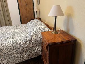 1 dormitorio con 1 cama con lámpara sobre una mesa de madera en Sarandí de Mariscala en Mariscala