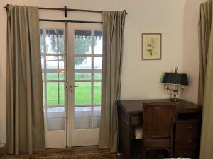 um quarto com uma secretária e uma porta de vidro deslizante em Sarandí de Mariscala em Mariscala