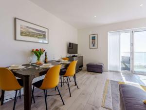 a dining room with a table and yellow chairs at 2 bed in Sandown 87079 in Sandown