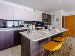 cocina con encimera con sillas amarillas en 2 bed in Sandown 87079, en Sandown