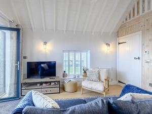 a living room with a couch and a tv at 2 Bed in Ogmore-by-Sea 86495 in Southerndown