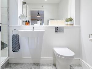 a white bathroom with a sink and a toilet at 2 Bed in Ogmore-by-Sea 86495 in Southerndown +14 photos