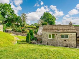 an old stone house with a grassy yard at 1 Bed in Ashford-in-the-Water 87471 in Great Longstone