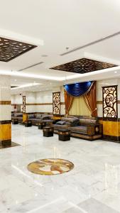a large lobby with couches and a clock on the floor at فندق انوار المشاعرالفندقية in Makkah