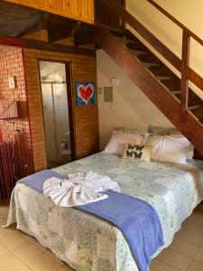 a bedroom with a bed with a wooden ladder at Chalés Dolce Vita in Monte Verde