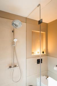 W łazience znajduje się prysznic ze szklanymi drzwiami. w obiekcie Le Petit Chalet w Braszowie