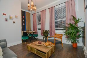 - un salon avec un canapé et une table dans l'établissement Cosy 1 bedroom home for small families, à Londres