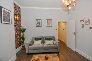 uma sala de estar com um sofá e uma mesa em Cosy 1 bedroom home for small families em Londres
