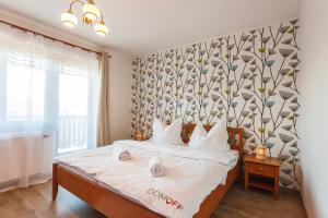 ein Schlafzimmer mit einem Bett und einer Wand mit einem Blumenmuster in der Unterkunft Vila Rozinka Lipno in Lipno nad Vltavou