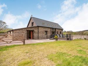 a stone barn with a fence and a grass field at 2 bed in Chepstow 87781 in Wolves Newton