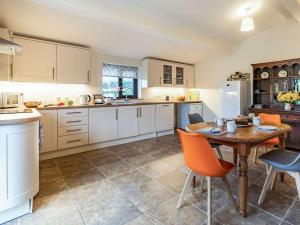 uma cozinha com uma mesa de madeira e cadeiras laranja em 2 bed in Chepstow 87781 em Wolves Newton
