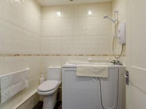 ein weißes Bad mit einem WC und einem Waschbecken in der Unterkunft 2 Bed in Bridport 88614 in Chideock
