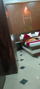 two beds with red pillows in a room at Shree Gorakhnath Guest House in Ayodhya