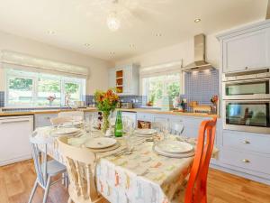 een keuken met een tafel met stoelen en een tafelkleed bij 3 Bed in Thirsk 88464 in Bagby