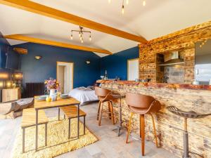 a kitchen and living room with blue walls and a bar at 1 Bed in Abergavenny 88015 in Llanover