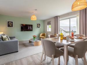 a living room with a dining room table with chairs at 2 Bed in St. Mellion 87710 in St. Mellion