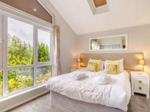een slaapkamer met een groot wit bed en een raam bij 2 Bed in Ilfracombe 87361 in Kentisbury
