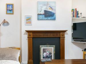 a living room with a fireplace with a ship on the wall at Pass the Keys Stunning 4BR Cafes and Restaurants Queens Uni in Belfast