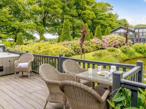 a table and chairs on a deck with a garden at 2 Bed in Ilfracombe 87361 in Kentisbury