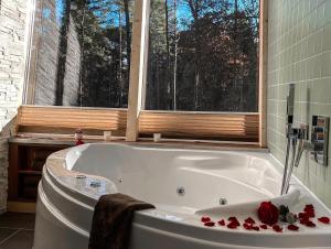 a bathroom with a white tub with roses on it at Tree Inn - Das Baumhaushotel in Dörverden