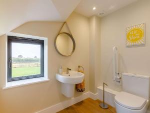 uma casa de banho com um lavatório, um WC e uma janela. em 3 Bed in Alcester 88396 em Coughton