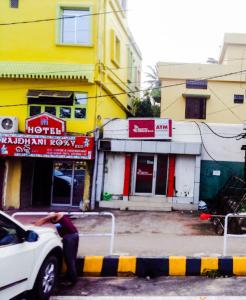 a person leaning on the back of a car on a city street at Hotel Rajdhani Roxy,Bhubaneswar in Bhubaneshwar