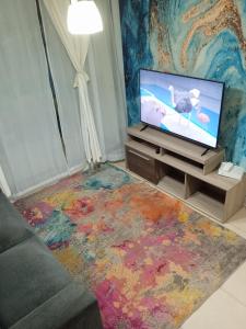 ein Wohnzimmer mit einem TV und einem farbenfrohen Teppich in der Unterkunft Dpto de playa 44 in Arica