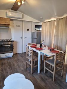 uma cozinha com uma mesa, cadeiras e um fogão em Mobile home Chic em Canet-en-Roussillon