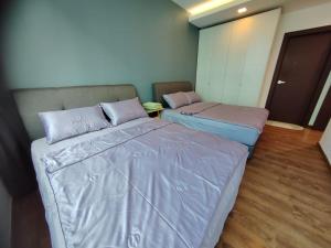 2 Betten in einem kleinen Zimmer mit ermottermottermott in der Unterkunft Aell Homestay Vivacity in Kuching