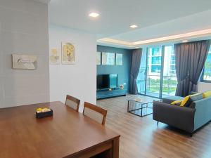 uma sala de estar com uma mesa, um sofá e uma televisão em Aell Homestay Vivacity em Kuching