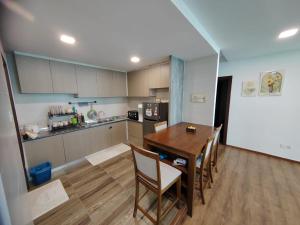 Aell Homestay Vivacity في كوتشينغ: مطبخ وغرفة طعام مع طاولة وكراسي