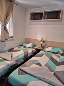 2 camas individuales en una habitación con ventana en Mobile home Chic en Canet-en-Roussillon