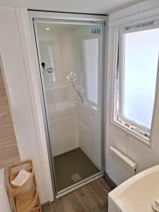a shower with a glass door in a bathroom at Mobile home Chic in Canet-en-Roussillon
