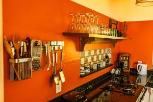 a kitchen with orange walls and a counter with utensils at Casa Papaya in Santa Cruz Cabrália