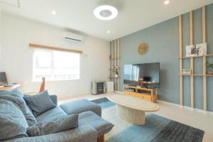 salon z kanapą i telewizorem w obiekcie furano ski rabi w mieście Furano