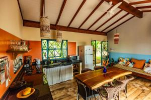 a kitchen and living room with a wooden table at Casa Papaya in Santa Cruz Cabrália