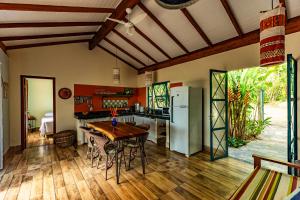 a kitchen with a wooden table and a refrigerator at Casa Papaya in Santa Cruz Cabrália +11 photos