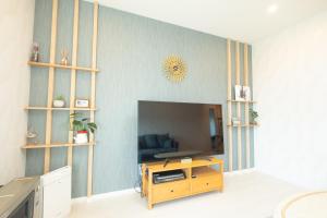 ein Wohnzimmer mit einem TV und einem Holztisch in der Unterkunft furano ski rabi in Furano