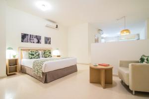 a white bedroom with a bed and a couch at Pierre & Vacances Sevilla in Seville +38 photos