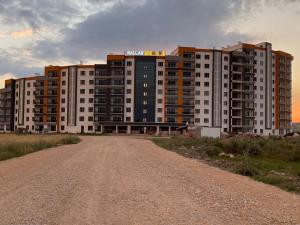 a dirt road in front of a large building at ÖYKÜM HOME 