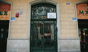 Una puerta a un edificio con un cartel. en Hostalet de Barcelona, en Barcelona