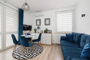 a living room with a blue couch and a table at Cracow Royal Blue Apartment Avia Estate by Renters in Kraków