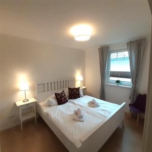 a bedroom with a white bed with two towels on it at Ferienwohnung Art in Born in Born