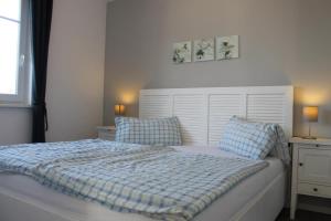 a bedroom with a bed with a blue and white comforter at Ferienwohnung Blue in Born in Born