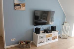 a flat screen tv sitting on a white entertainment center at Ferienwohnung F 86 in Born in Born